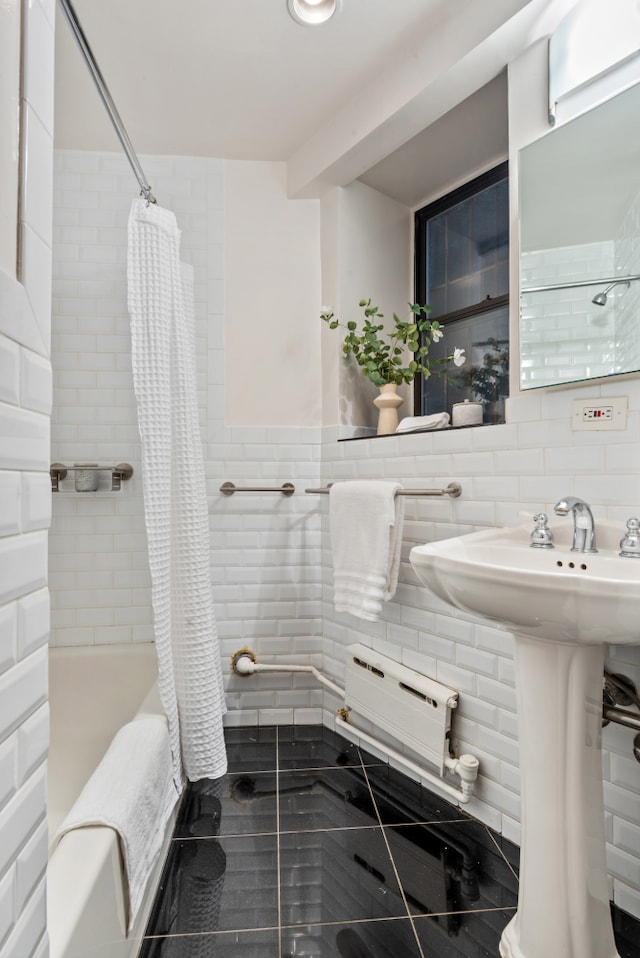 bathroom with shower / tub combo, a sink, tile walls, and tasteful backsplash