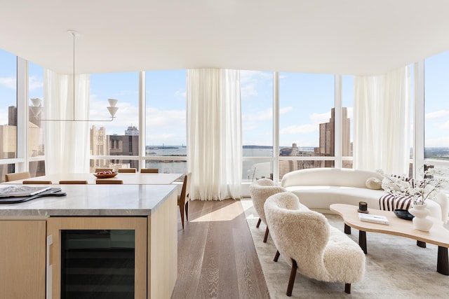 interior space featuring beverage cooler, expansive windows, a city view, and wood finished floors