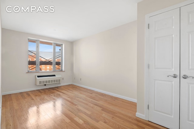 empty room with baseboards, heating unit, and wood finished floors