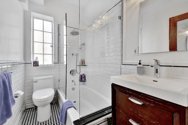 full bathroom featuring vanity, tile walls, toilet, and tub / shower combination