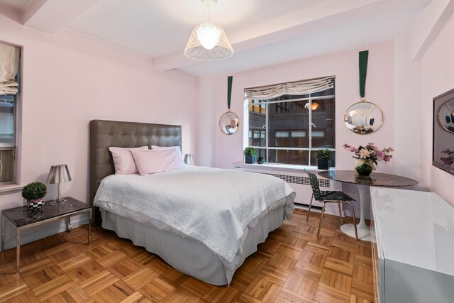 bedroom with light parquet floors and radiator heating unit