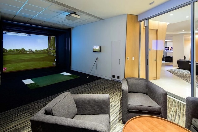 game room with golf simulator and a drop ceiling