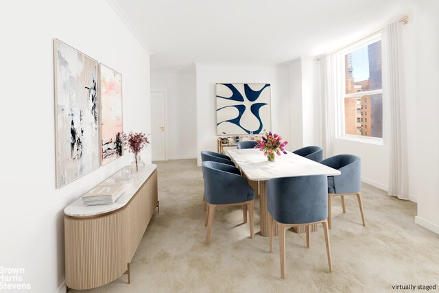 carpeted dining room featuring crown molding