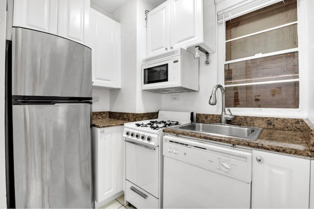 kitchen featuring white cabinets, dark stone counters, sink, and white appliances