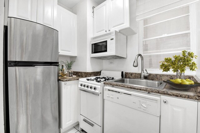 321 E 45th St Unit 8H, New York City, NY 10017 - kitchen with white appliances, a sink, white cabinets, and dark countertops