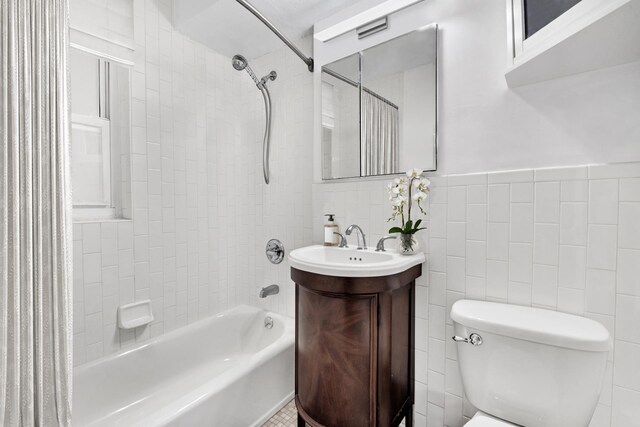 321 E 45th St Unit 8H, New York City, NY 10017 - bathroom with  shower combination, toilet, vanity, tile walls, and wainscoting