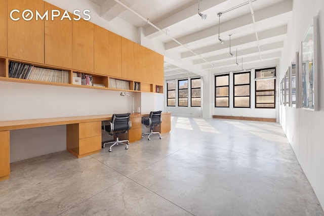 home office with finished concrete flooring and built in desk