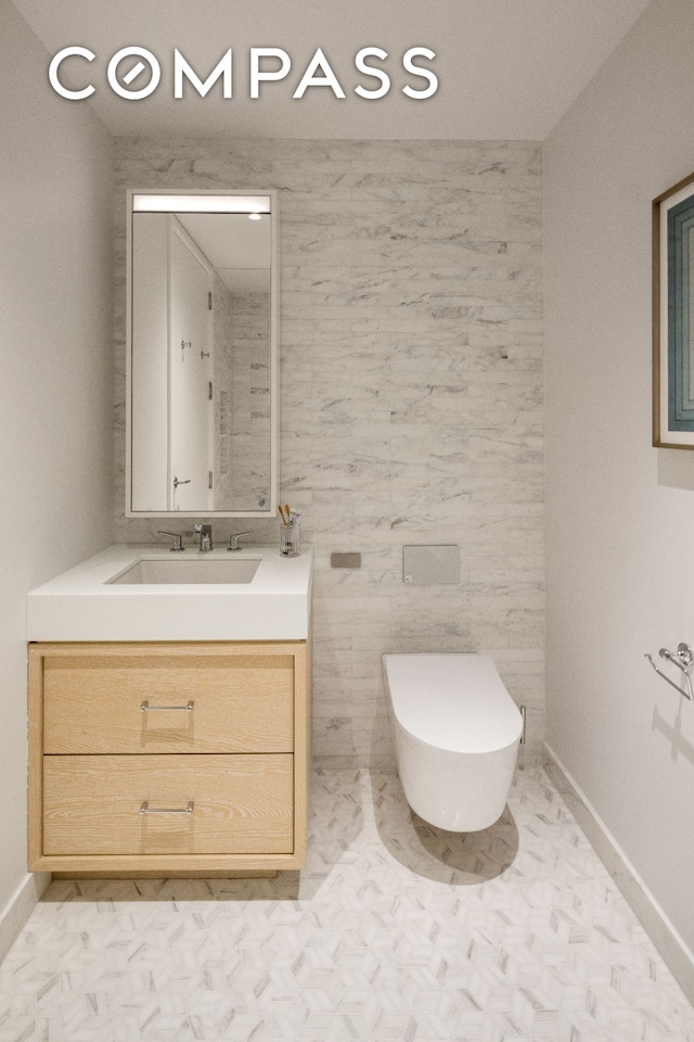 bathroom with baseboards, toilet, tile walls, and vanity