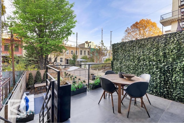 view of patio featuring outdoor dining space and fence