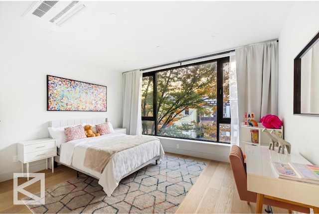 bedroom featuring multiple windows, wood finished floors, and visible vents