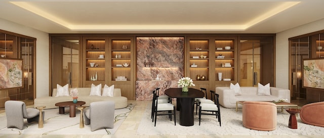 sitting room with a raised ceiling and built in shelves