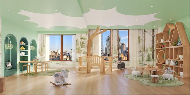 workout room with wood finished floors and a city view
