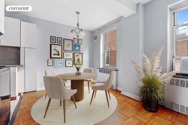 dining room featuring radiator, an inviting chandelier, and light parquet floors