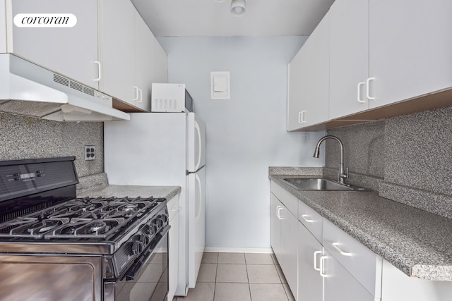 kitchen featuring white cabinets, decorative backsplash, sink, black gas stove, and light tile patterned floors