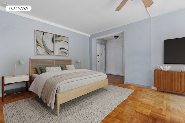 bedroom with ceiling fan and light parquet flooring