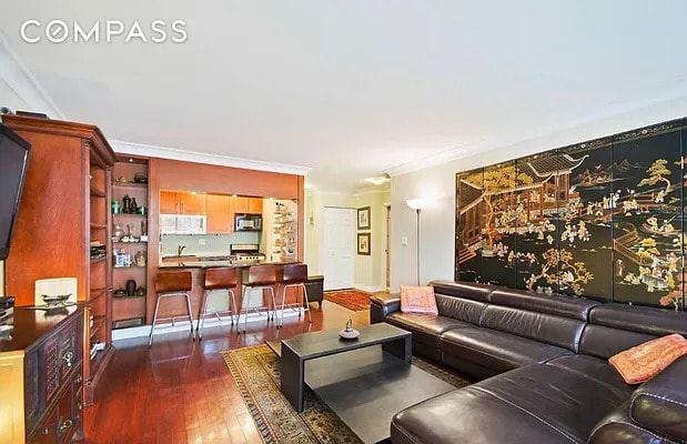 living area with dark wood-type flooring and ornamental molding