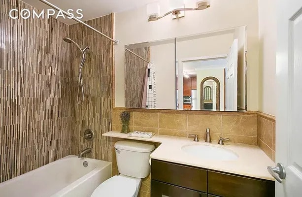 full bath featuring vanity, toilet, tile walls, and  shower combination