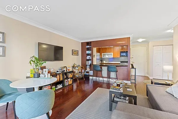 living area with dark wood-type flooring and crown molding