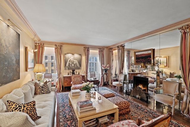 living area featuring ornamental molding, plenty of natural light, a lit fireplace, and wood finished floors