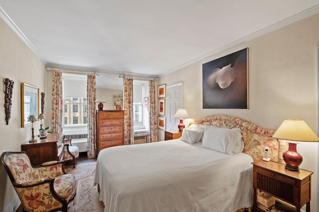 bedroom with ornamental molding and wood finished floors