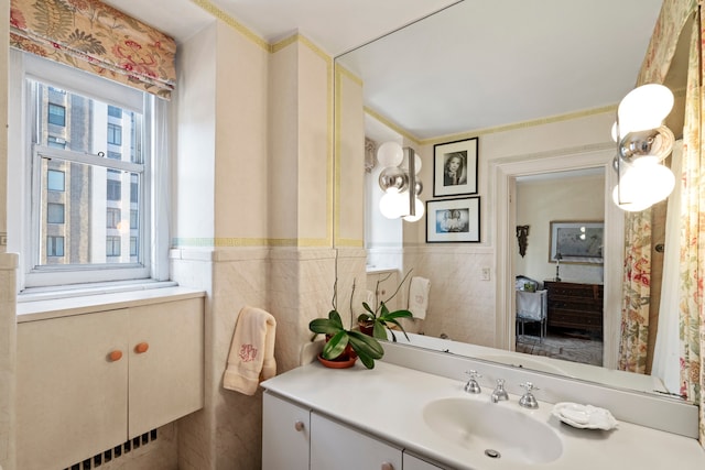 bathroom with a wainscoted wall, vanity, and tile walls