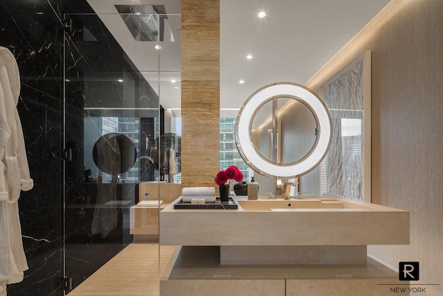bathroom with a marble finish shower and vanity