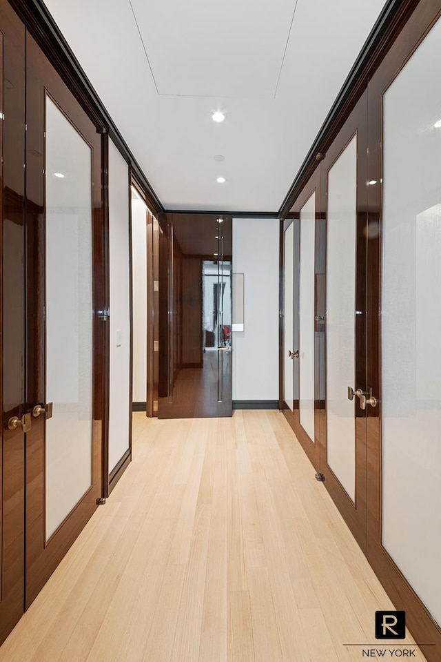 corridor with light wood finished floors and recessed lighting