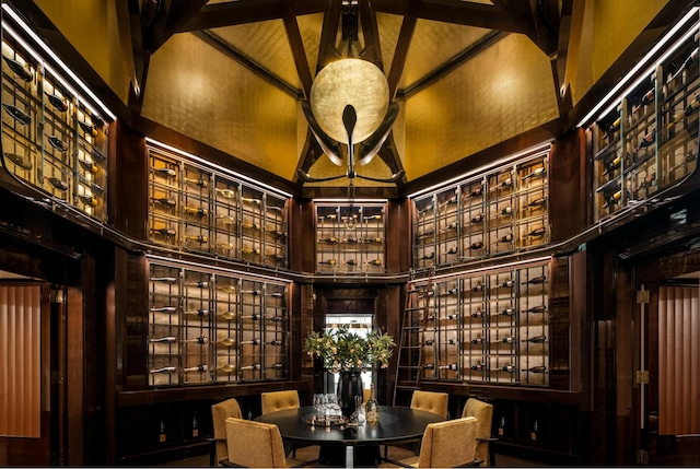 wine room with high vaulted ceiling and beamed ceiling