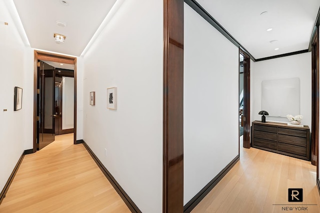 corridor with crown molding and light wood-type flooring