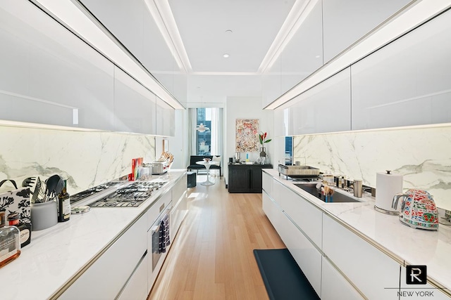 kitchen with modern cabinets, white cabinetry, and backsplash