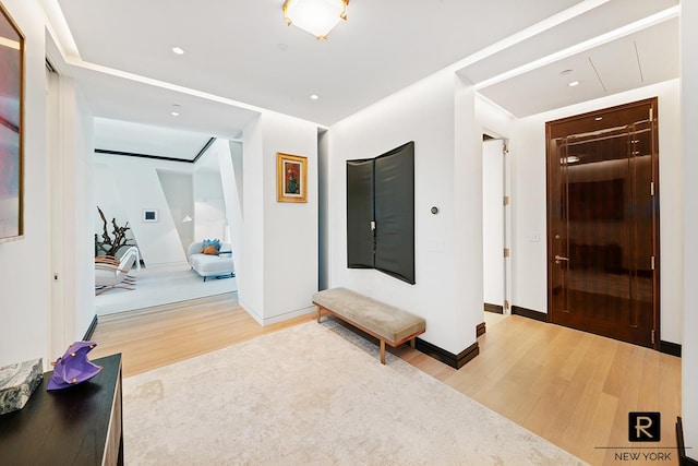 hallway with wood finished floors, baseboards, and recessed lighting