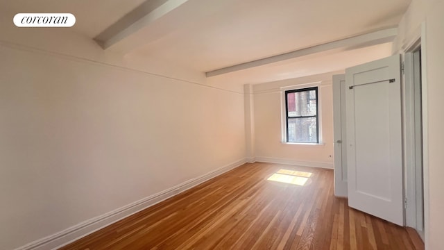 319 E 50th St Unit 5G, New York City, NY 10022 - unfurnished bedroom featuring wood finished floors and beamed ceiling