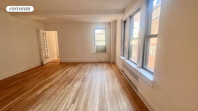 319 E 50th St Unit 5G, New York City, NY 10022 - unfurnished room with wood finished floors and baseboards