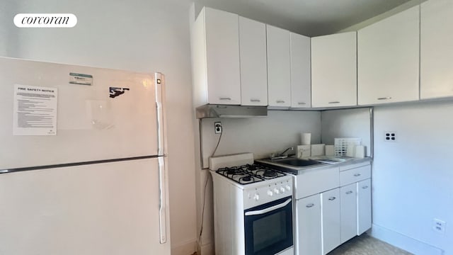 319 E 50th St Unit 5G, New York City, NY 10022 - kitchen featuring white appliances, under cabinet range hood, light countertops, and white cabinets