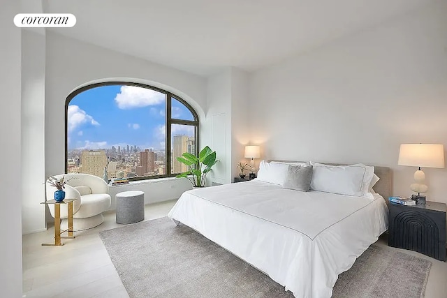 bedroom featuring a view of city, visible vents, and wood finished floors