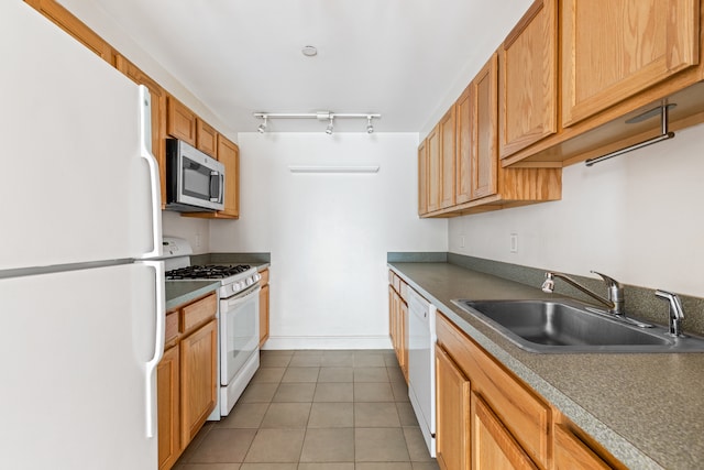 kitchen with light tile patterned floors, track lighting, white appliances, and a sink