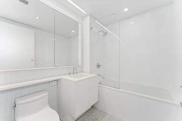 full bathroom featuring tile walls, toilet, vanity, and shower / washtub combination