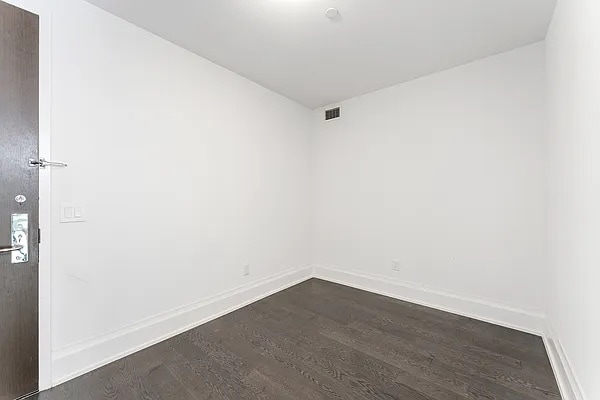 unfurnished room with dark wood-type flooring