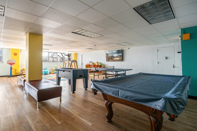 recreation room with a paneled ceiling, pool table, and hardwood / wood-style floors