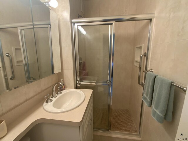 bathroom with a shower with shower door, tile walls, and tile patterned flooring