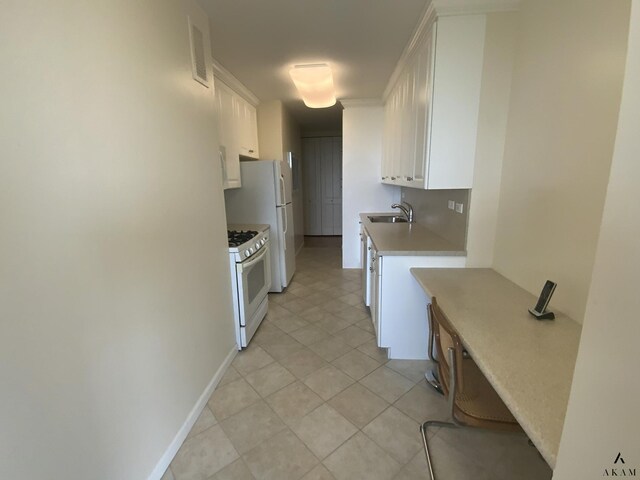 kitchen with visible vents, light countertops, white gas stove, white cabinetry, and a sink