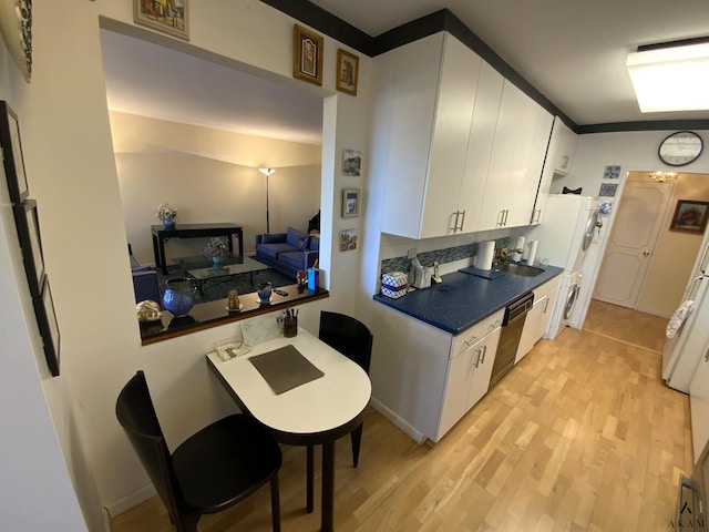 kitchen with white cabinets, light wood-style flooring, dark countertops, and dishwashing machine