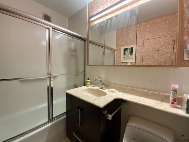 full bathroom with visible vents, toilet, enclosed tub / shower combo, vanity, and backsplash