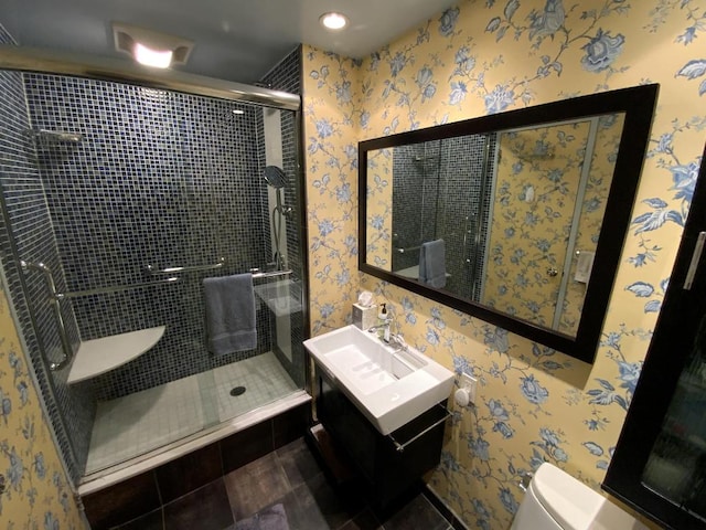 bathroom featuring a shower stall, toilet, and wallpapered walls