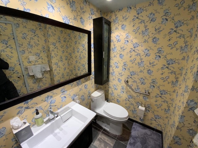 bathroom with toilet and wallpapered walls