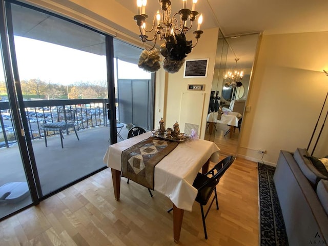 dining area featuring baseboards, wood finished floors, visible vents, and an inviting chandelier