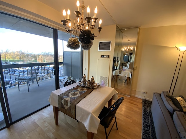 dining space featuring visible vents, a chandelier, and wood finished floors