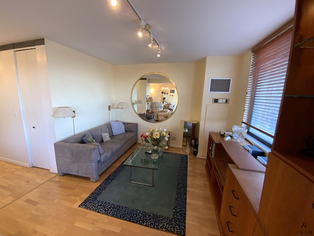 living area featuring light wood-style floors, baseboards, rail lighting, and visible vents