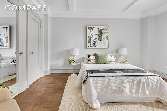 bedroom featuring beamed ceiling and baseboards