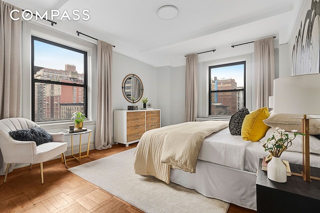 bedroom featuring multiple windows and a city view